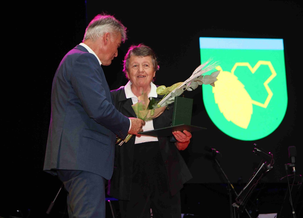 Župan Občine Žalec Janko Kos izroča Silvi Potočnik priznanje.